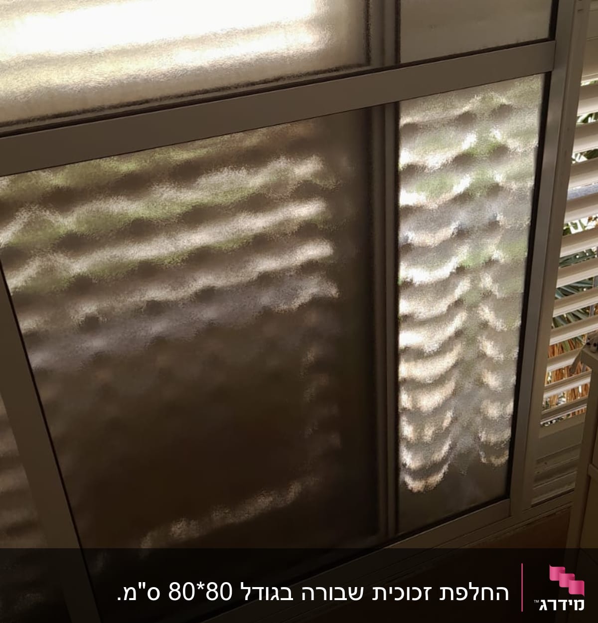 חלון זכוכית עם טקסטורה גלית ואור שמש